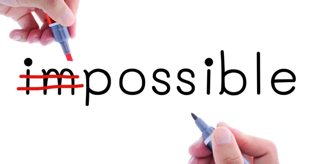 「impossible」の文字の「im」を赤いペンで消して、「possible」に変えている手元の画像。ポジティブな変化を象徴するイメージ。