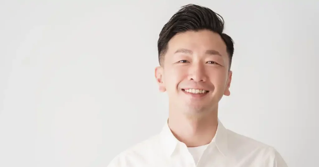 面接での清潔感を重視した髪型と表情を示す男性の画像。白いシャツを着用し、丁寧に整えられた髪型が清潔感を強調している。