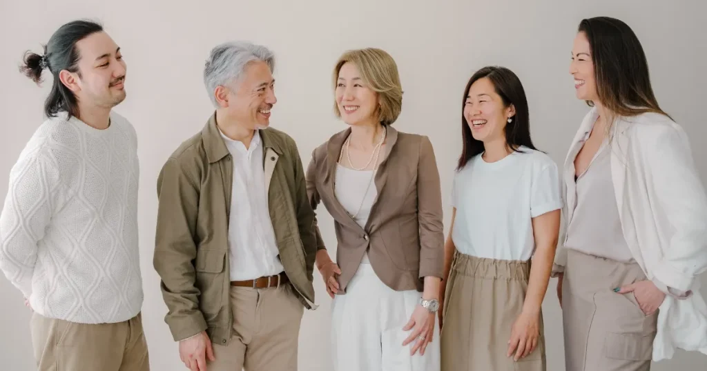 職場で笑顔を交わす多世代の同僚たち。50代転職に求められるスキルを象徴する和やかな場面。