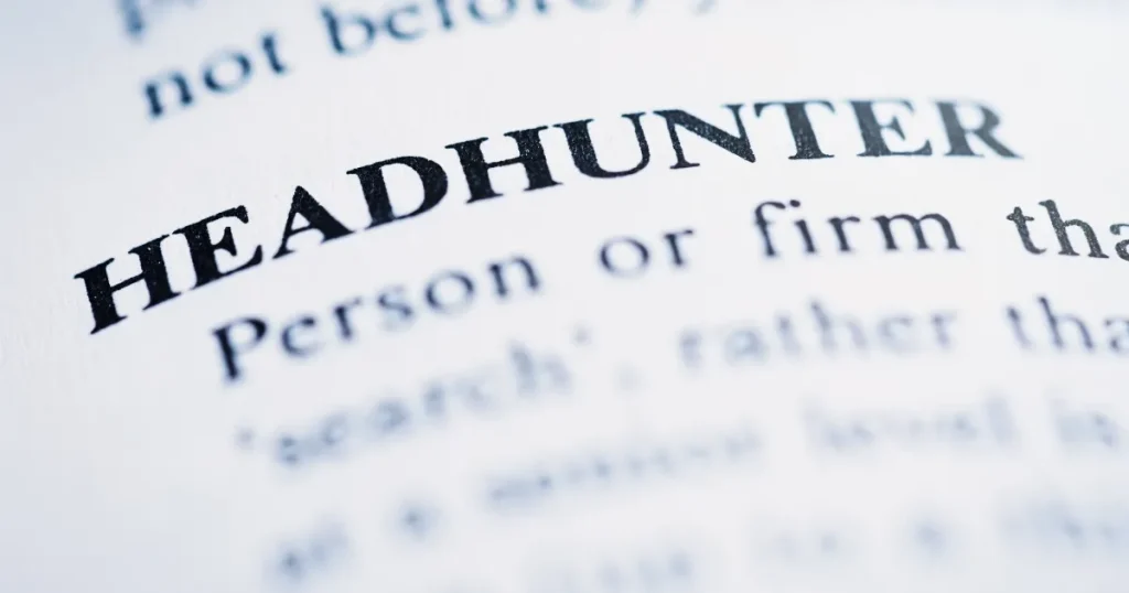 ヘッドハンター（Headhunter）の定義が印刷された辞書の一部をクローズアップした画像。ヘッドハンティングの概念を象徴するビジュアル。