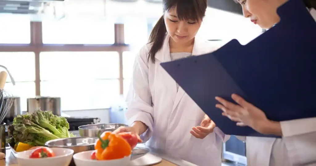 食品の商品開発に取り組む研究者たち。新鮮な野菜を使い、試作やコンセプト設計について話し合う様子。