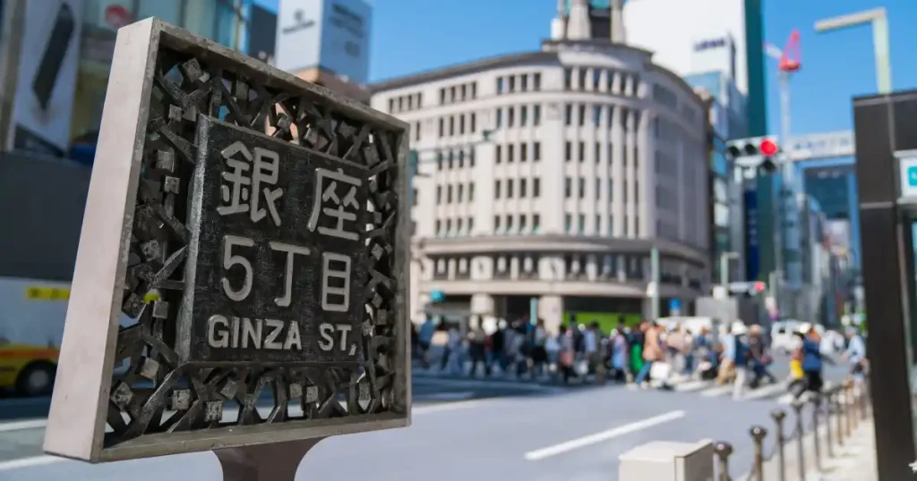 東京・銀座の街並みを写した画像。「銀座5丁目」と記された標識と背景に見える交差点、賑やかな人々の様子が特徴的で、東京の活気や魅力を象徴しています。