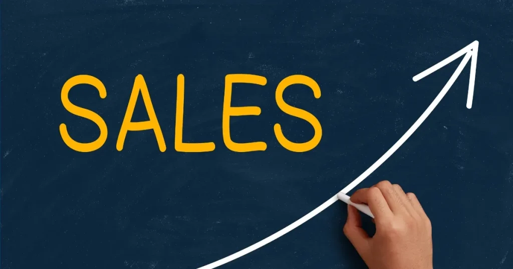 黒板に描かれた『SALES』の文字と右肩上がりの矢印。営業職の業績向上や成果を象徴するイメージ。