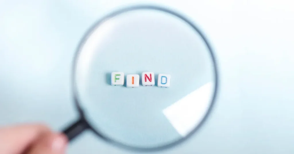 「FIND」と書かれたカラフルなキューブ文字を拡大する虫眼鏡のイメージ。自己分析で自分を見つけるプロセスを象徴。