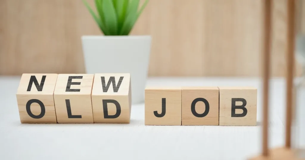 「NEW」「OLD」「JOB」と書かれた木製ブロックが並ぶ。背景には観葉植物があり、転職やキャリアチェンジを象徴するイメージ。