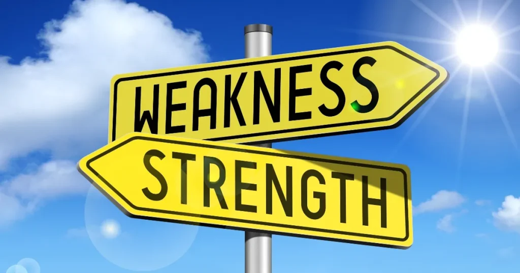 青空の下、「WEAKNESS（弱み）」と「STRENGTH（強み）」と書かれた黄色い標識が交差するデザイン。転職活動での自己分析の方向性を示唆するイメージ。