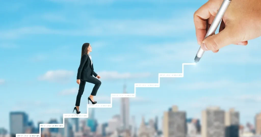 青空を背景に、スーツ姿の女性が階段を上っているイメージ。その階段はペンで描かれており、ハイキャリア転職のステップアップを象徴している。