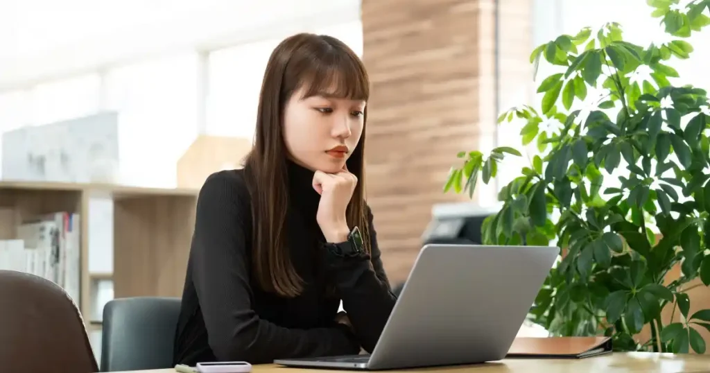 就職活動でMBTIを活用する女性|パソコンを使って性格分析を行い、自己理解を深める様子を描いた写真