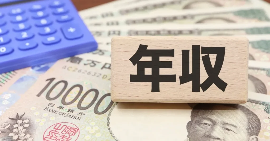 「年収」と書かれた木製プレートと日本円の札束、電卓が並ぶイメージ 年収アップを狙いやすい職種を解説するセクションの象徴的な画像