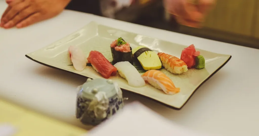 寿司職人としての実感｜盛り付けられた握り寿司の皿と職人の手元、提供時の緊張感と喜びを表現