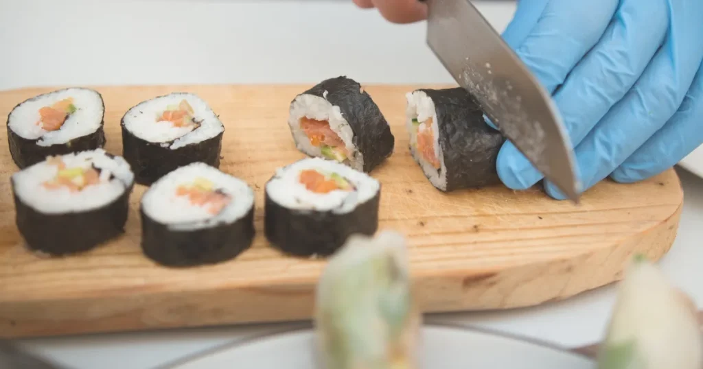 寿司職人への転職を目指す理由｜巻き寿司を丁寧にカットする様子、調理技術への意欲を反映