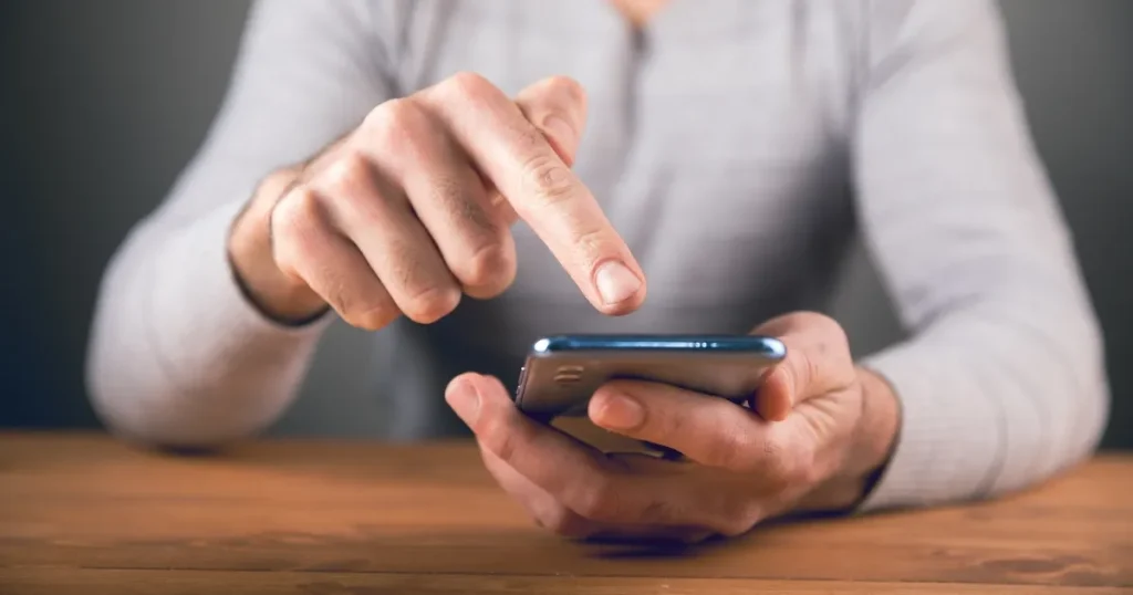 就活で企業に電話をかける前に準備をする様子。問い合わせ内容を整理し、スマホを手にした男性のイメージ