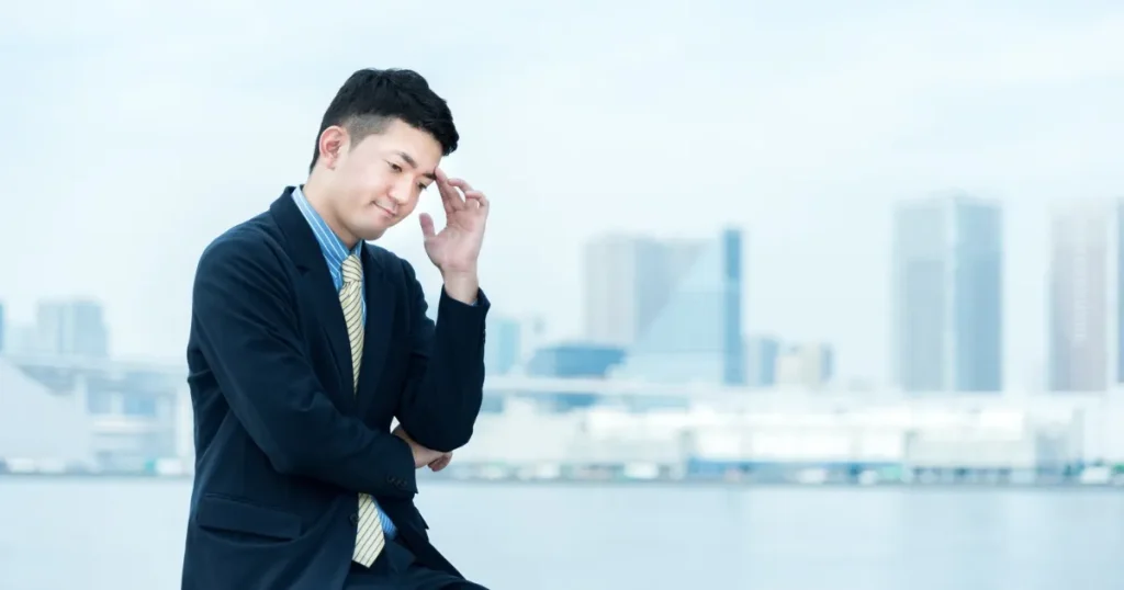 転職活動で悩む際の相談先を考えるためにスーツ姿の男性が思案している様子