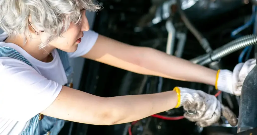 女性自動車整備士が整備作業を行う様子。女性が自動車整備士業界で長期的に活躍するためのポイントを説明するセクションのイメージ画像。