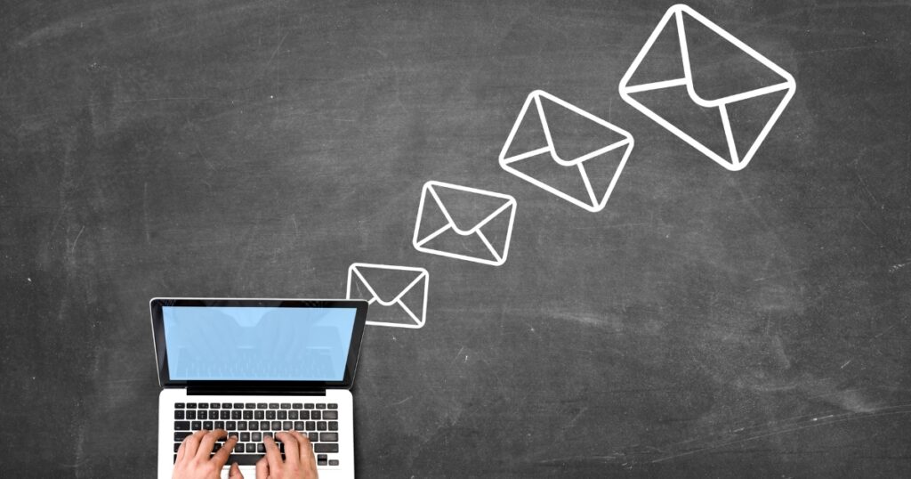 ノートパソコンの上に送信されるメールアイコンが描かれたイメージ図。就活での問い合わせメールの基本構成を説明するセクションに関連。