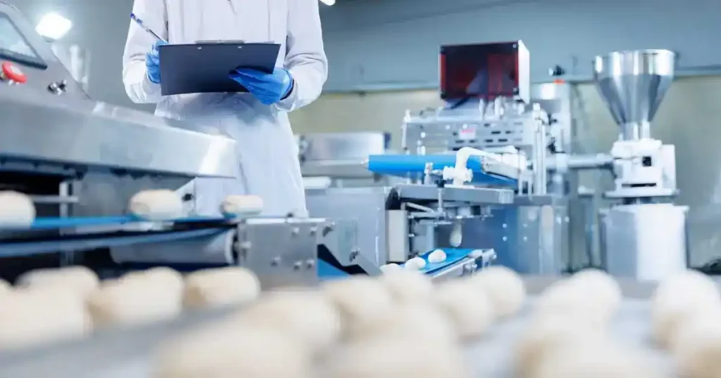 食品工場で製菓衛生師が製造ラインのチェックをしている様子。製菓衛生師資格を実務でどのように活かせるかを解説するセクションに関連するイメージ。