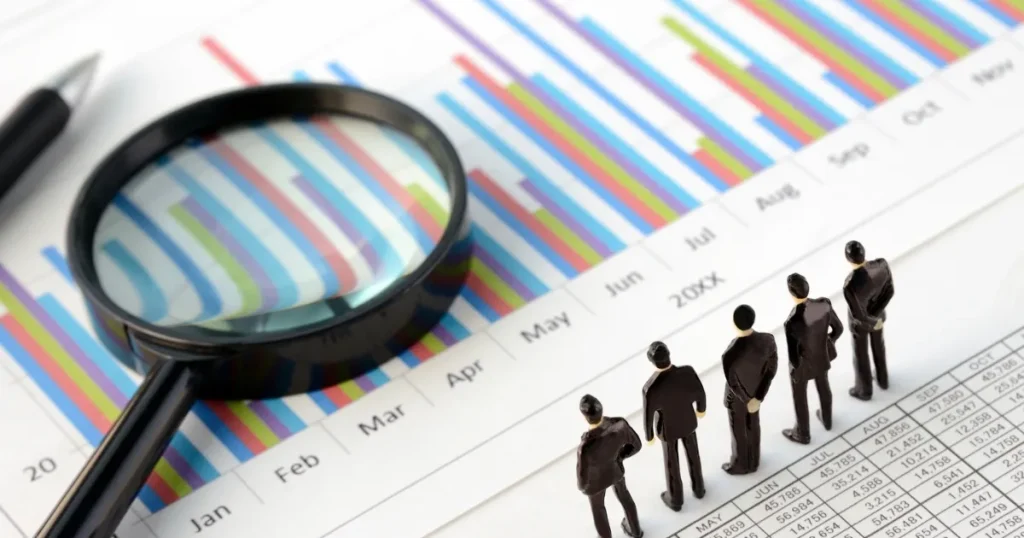 拡大鏡でカラフルなグラフを分析する場面と、小さな人形がデータを観察する様子。就活における自己分析の基本的な流れを解説するセクションのイメージ画像。