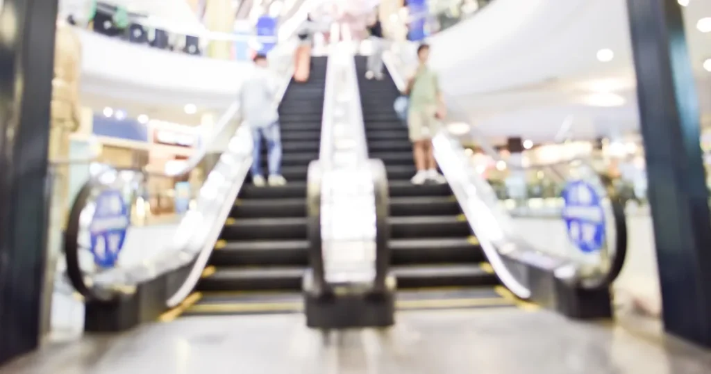 ショッピングモール内のエスカレーター。転職先としてのグロサリー部門に進むためのステップを連想させるイメージ。