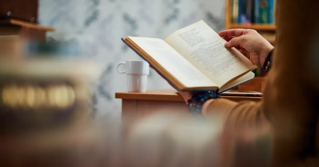 静かな空間で本を開いて読む人の手元の写真。転職で自己分析本を活用するメリットについて説明する記事セクションに関連するビジュアル。