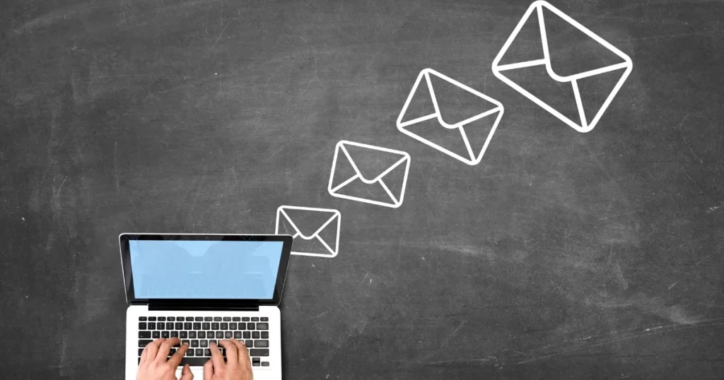 ラップトップから送信されるメールを象徴するアイコンが描かれた黒板風背景。転職の問い合わせでメールを送る基本マナーを示すイメージ。