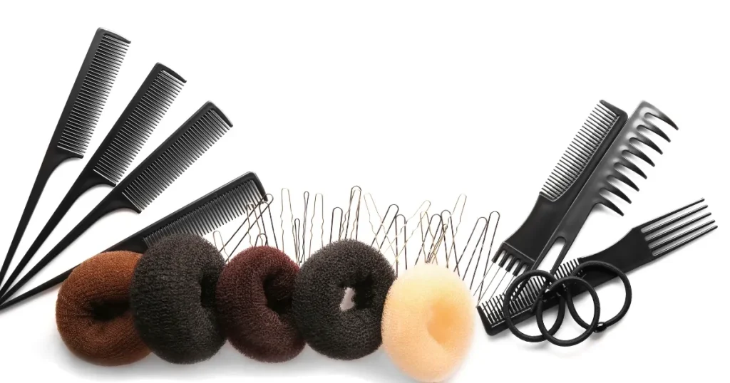 白い背景に並べられたシニヨン用のヘアアクセサリーやコーム、ヘアピン、ヘアゴム。採用担当者に好印象を与えるシニヨンアレンジ術を説明するセクション用のビジュアル。