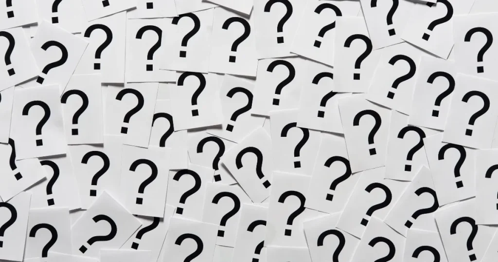 多数のクエスチョンマークが描かれたカードが散らばる様子。面接の逆質問に関する疑問やQ&Aを象徴するイメージ。