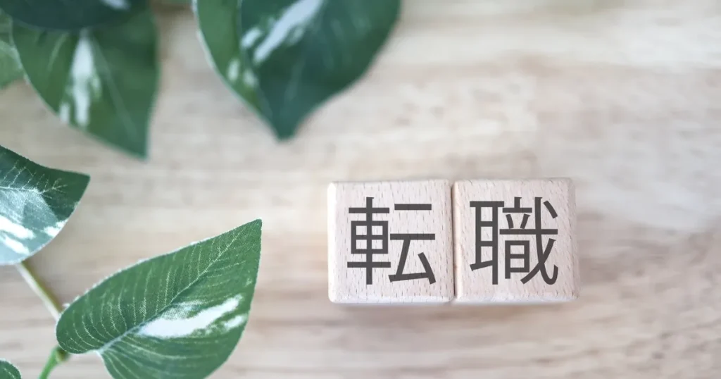 転職と書かれた木製ブロックで、宅建資格を活かして不動産業界へ転職するときの注意点を表すイメージ
