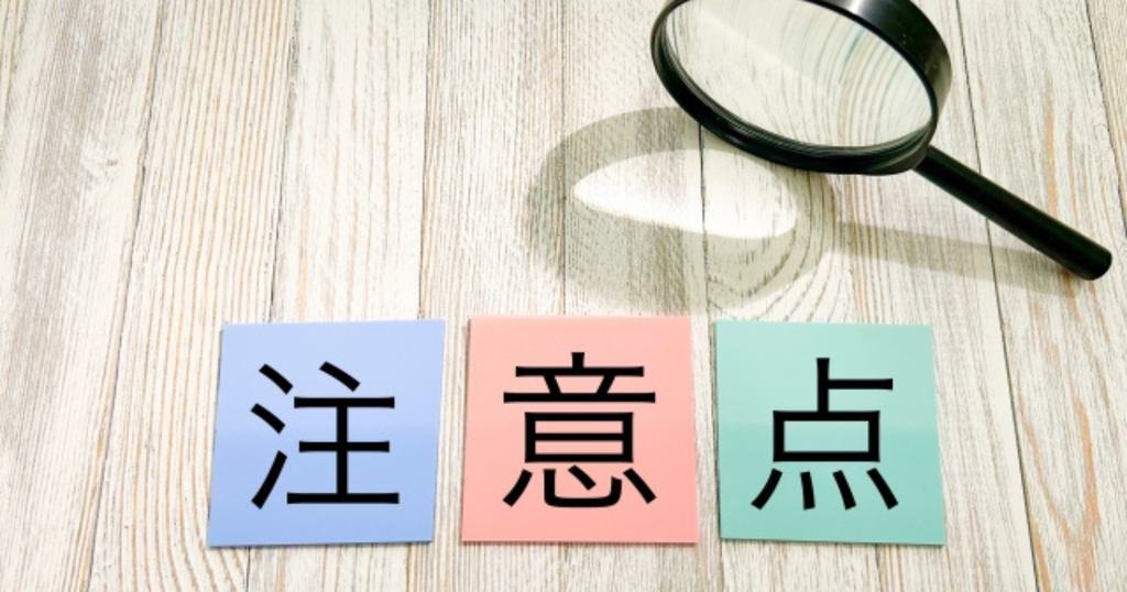 虫眼鏡と「注意点」と書かれたカードで、職務経歴書を書くときや提出前に確認すべき注意点をイメージした画像